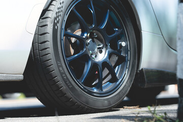 Part of a sports car. Various angles. Sports car parked at a parking spot. There is daylight.