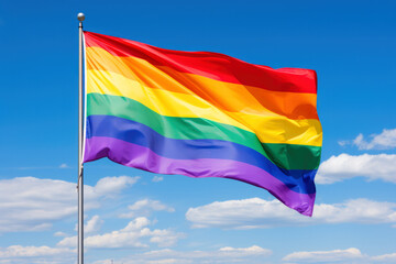 Rainbow Flag against blue sky and white clouds