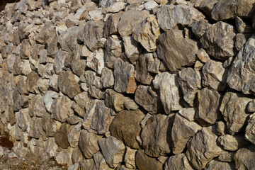 Wall of uneven stones near the road