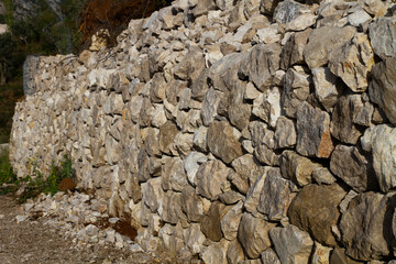 Wall of uneven stones near the road