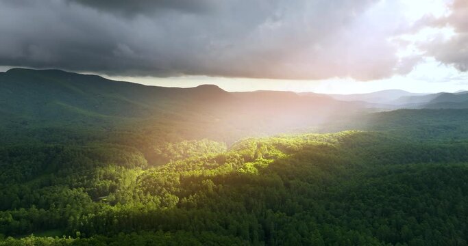 Beautiful nature scenery. Sun beams shining on mountain woods through clouds in North Carolina Appalachians