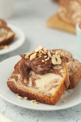 A piece of marble biscuit with chocolate cream and nuts