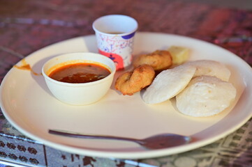 cup of coffee and south indian breakfast. idli and fried vada. Bowl with sambar.  Indian food