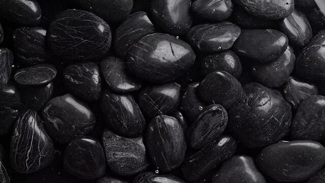 Black pebbles under water ripple