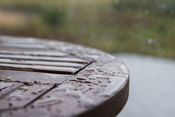A table on the balcony, wet from raindrops. Close-up of drops