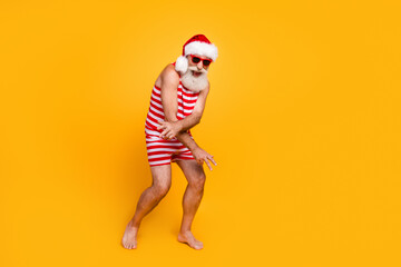 Full length photo of positive cheerful senior guy dressed christmas swimwear dance discotheque empty space isolated yellow color background