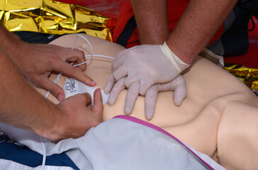 Emergency worker, paramedic hands pressing on a sufferers chest, keeping an oxygen cushion on his...