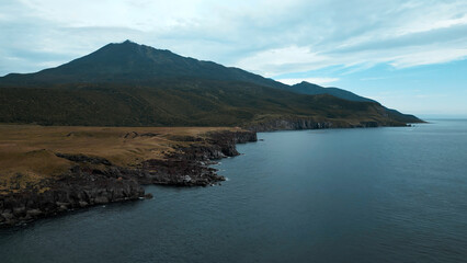 Aerial stunning natural landscape with beautiful mountains and azure calm sea. Clip. Concept of wild untouched nature.