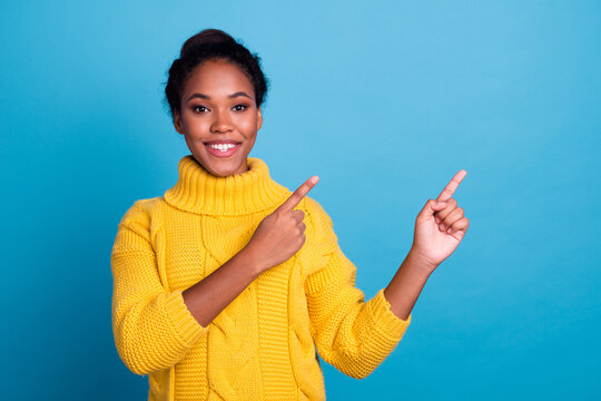 Image of happy young lady standing isolated over blue background. Looking camera pointing