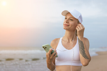 Running woman. Female runner with her smartphone training outdoor workout on beach. 