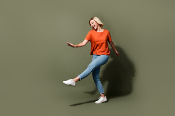 Fototapeta na wymiar Full size photo of pretty young girl dancing bachelorette disco event prom dressed stylish orange outfit isolated on khaki color background