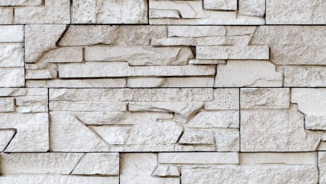 Wall, masonry of flat chipped stones beige split uneven convex, moving sideways, close-up macro
