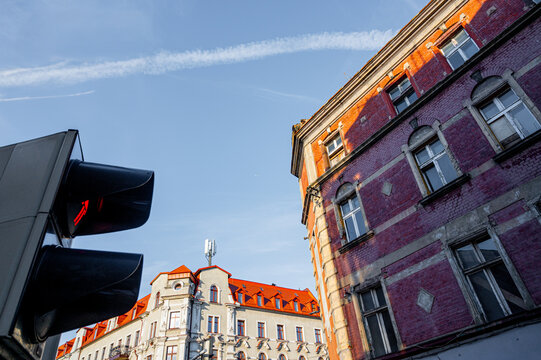 Old city with beautiful facades traffic light and sky with chemtrail