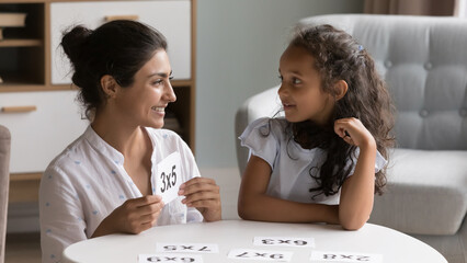 Loving Indian mother show flash cards to 6s girl, check daughter knowledge in multiplication during...