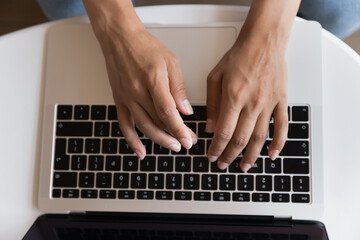 Fototapeta na wymiar Top view unknown female hands typing on laptop keyboard. Businesswoman contact to client by e-mail, makes order through ecommerce services, buying goods on-line. Freelance, blogging, telework concept