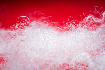 Extreme macro of polyester stable fiber on red background