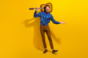 Full body photo of optimistic man wear vintage bow tie stand with guitar announcing concert on poster isolated on yellow color background