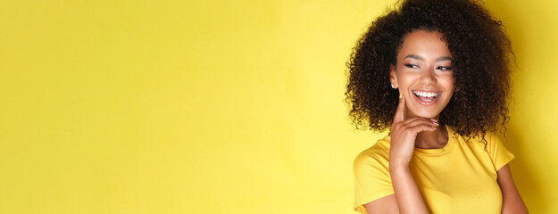 Cute female with curly hair on yellow background.