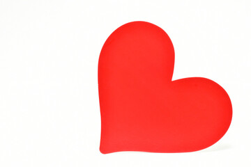 Corazón rojo sobre fondo blanco, espacio para texto al lado izquierdo. 