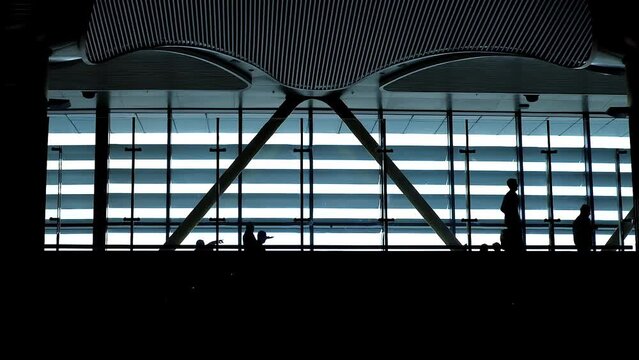 Silhouette of People Walking Against Lounge Window. Modern International Airport