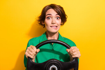Photo of funky nervous lady wear green shirt biting lip riding automobile isolated yellow color...