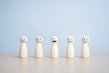 A happy smiling wooden figure stands in the center among many state emotion figures. Individuality,...
