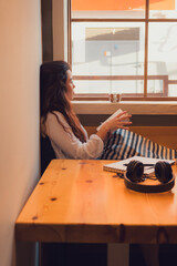 Relaxed woman in a coffee shop reading a book near a window