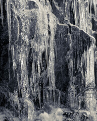Frozen water fall on a granite rock face cliff in mid winter conveys cold, frigid, icy conditions