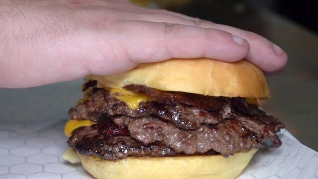 man stacking a doble cheese burger with american cheese