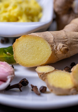 Root and grated ginger placed on a ceramic tray