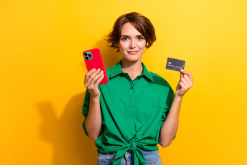 Photo of cheerful positive girl dressed green shirt online shopping modern gadget isolated yellow color background