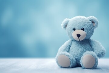 A blue teddy bear sits on a blue background