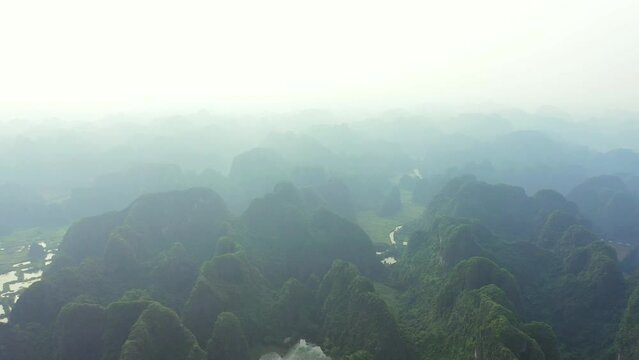 Drone, landscape and river in mountains with fog in the sky of jungle, nature and environment in Vietnam. Green, hills and clouds on horizon in tropical farm, forest or countryside with bush in woods