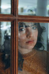 portrait through door window of young woman