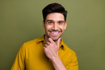 Portrait of intelligent successful person beaming smile hand touch chin empty space isolated on khaki color background