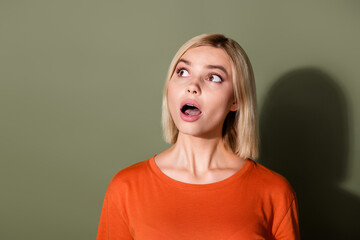 Photo portrait of pretty young girl look shocked empty space dressed stylish orange outfit isolated on khaki color background