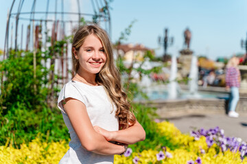 Obraz na płótnie Canvas Cute teenage girl in a flower garden, portrait