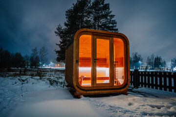 Wooden sauna in a snowy landscape at night
