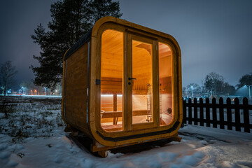 Wooden sauna in a snowy landscape at night
