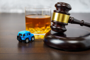 Judge's mace on a table in a court of law, glass of whiskey and miniature car. No drinking while driving concept - obrazy, fototapety, plakaty