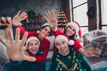 Portrait of group excited positive buddies hands waving hi new year greeting decorated apartment...