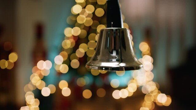 Shaking and ringing bell with blurred Christmas background