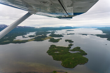 Aerial view from seaplane of Lake Iliamna with islands, Aleutian mountain range and reflection....