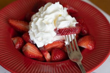 Strawberries and cream on a red plate