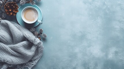  a cup of coffee next to a blanket, pine cones, and a pair of scissors on a blue background. - obrazy, fototapety, plakaty
