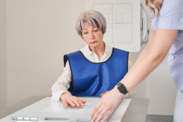 Cropped view of the woman GP or therapist making x ray to unhealthy mature female patient