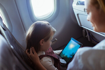 Child Watching Tablet on Airplane with mother
