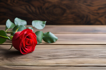 Single red rose lying on a wooden table. Valentine's Day composition. Design for minimalist posters, greetings, or invitations with free space for text