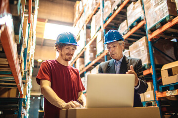 Senior Manager and Warehouse Employee Discussing Inventory