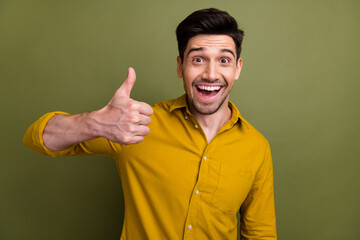 Portrait of attractive astonished person beaming smile arm finger demonstrate thumb up isolated on...